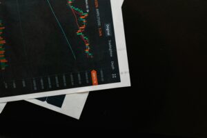 Detailed close-up of a financial chart on a black surface, showing stock market analysis.